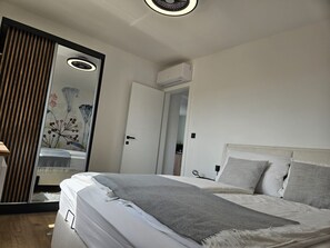 Ein Schlafzimmer mit einem Bett, einem Kleiderschrank und einem Spiegel.