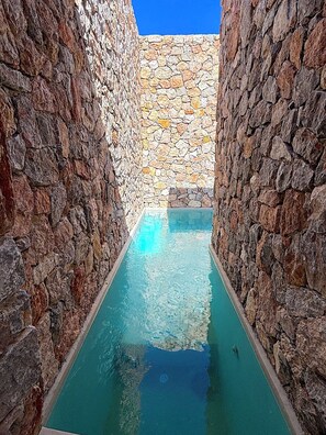 A narrow stone-lined pool with clear water, surrounded by stone walls. - Villa  Nira (Episkopi Gonias)