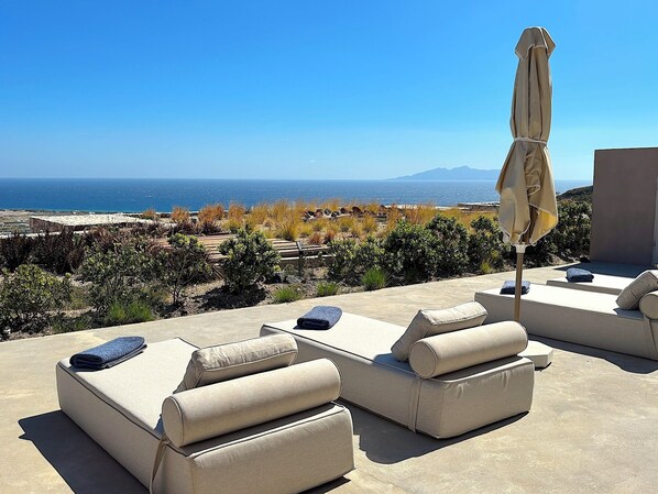 A terrace with outdoor furniture and a view of the sea. - Villa  Nira (Episkopi Gonias)