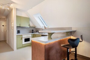 Eine moderne Küche mit einer zentralen Kochinsel, einem Barhocker und einem Oberlicht.