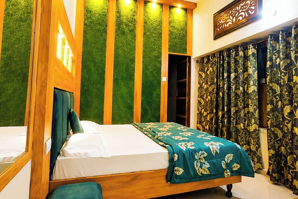 A bedroom with a bed, a bench, a ceiling fan, and a wall with vertical wooden panels.