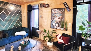 A wooden interior with a blue sofa, a painting, and a plant. - In the heart of Font Romeu, a lovely house. (Font-Romeu-Odeillo-Via)
