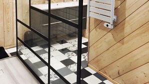 A bathroom with a black and white checkered floor, a white towel rack, and a wooden ceiling. - In the heart of Font Romeu, a lovely house. (Font-Romeu-Odeillo-Via)