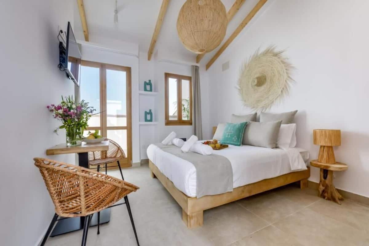 Une chambre à coucher avec un lit, une table de chevet, une lampe et une chaise.