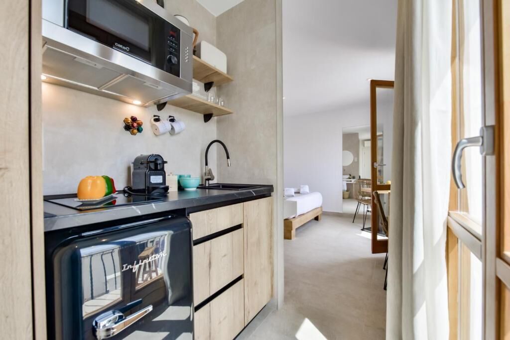 A compact kitchen with a microwave, coffee maker, and a small refrigerator.