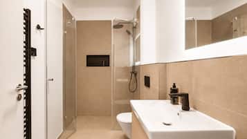 Un baño moderno con ducha, inodoro y lavamanos.
