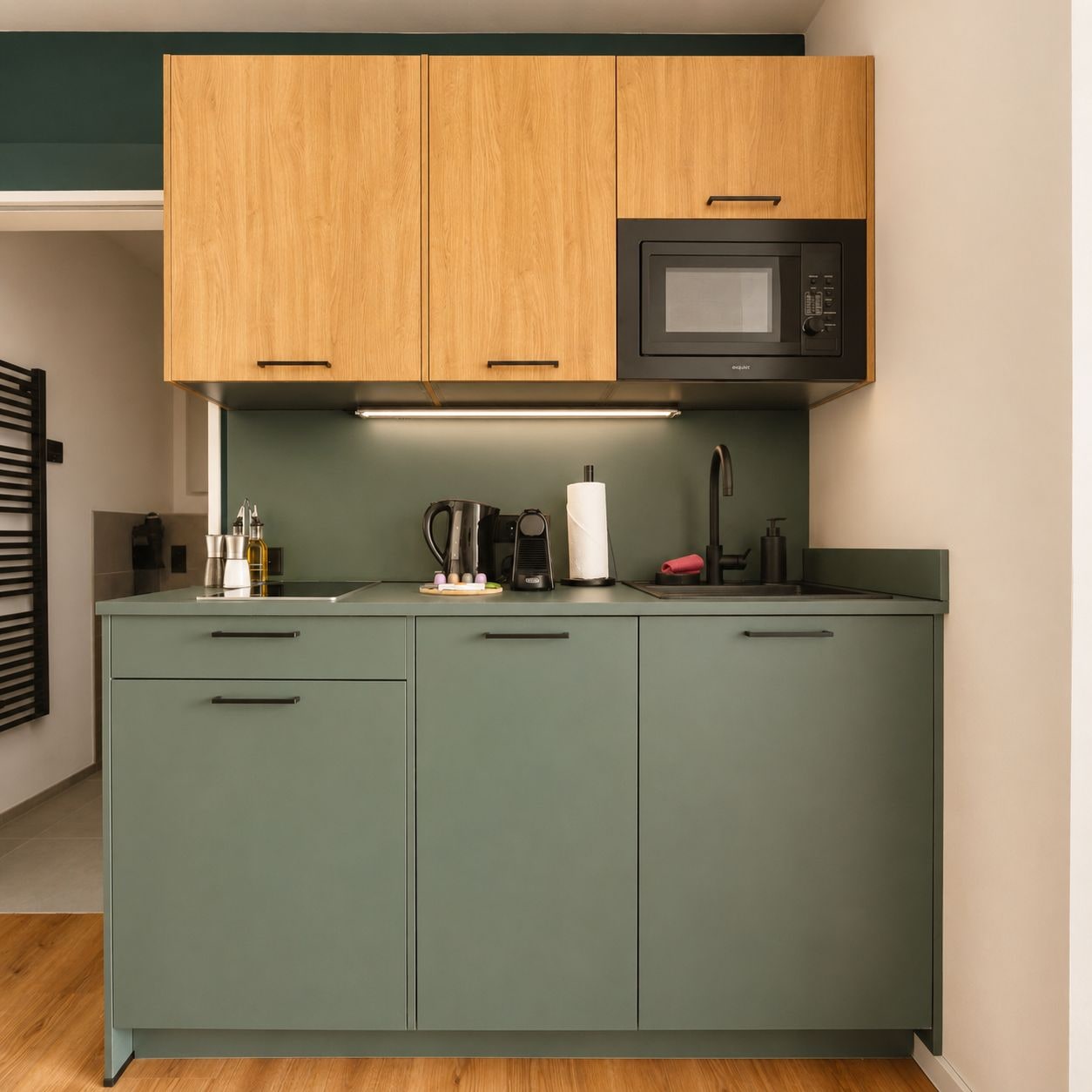 A compact kitchen with a microwave, a coffee maker, and a sink.