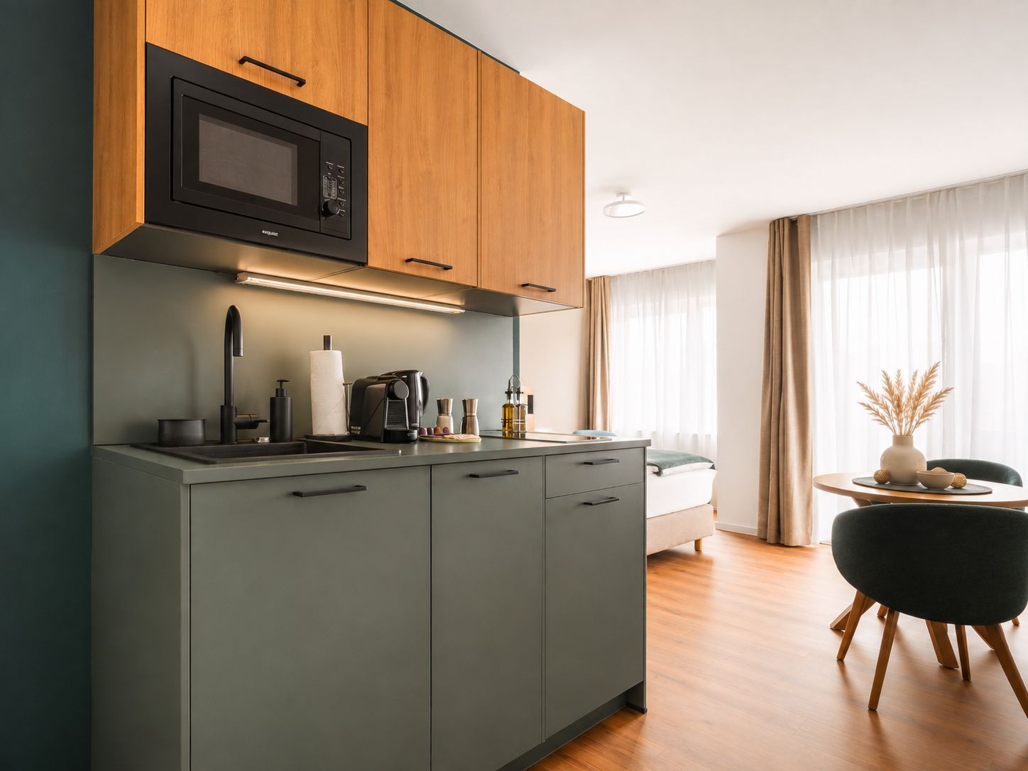 A modern kitchen with a built-in microwave, a coffee machine, and a sink.