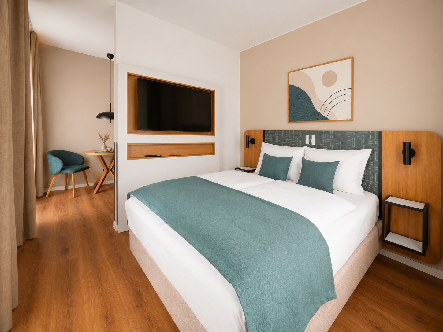 Una habitación de hotel moderna con una cama grande, un televisor de pantalla plana en la pared, un escritorio pequeño con una silla y un adorno en la pared sobre la cama.