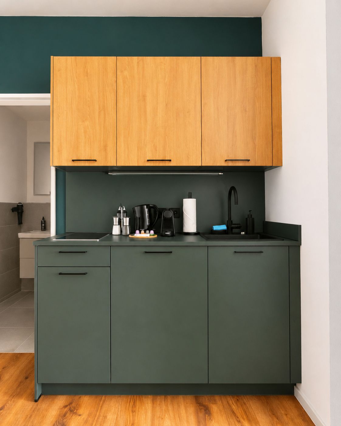 A modern kitchen with a central island, wooden upper cabinets, and a dark green countertop.