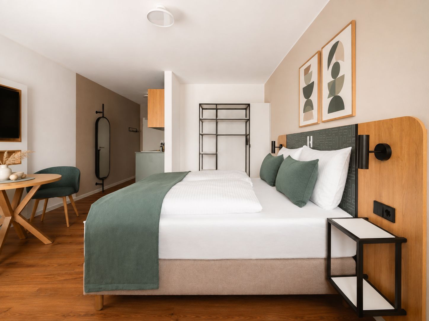 Ein modernes Hotelzimmer mit Bett, Nachttisch und Schreibtisch mit Stuhl.