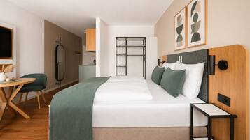 Ein modernes Hotelzimmer mit Bett, Nachttisch und Schreibtisch mit Stuhl.