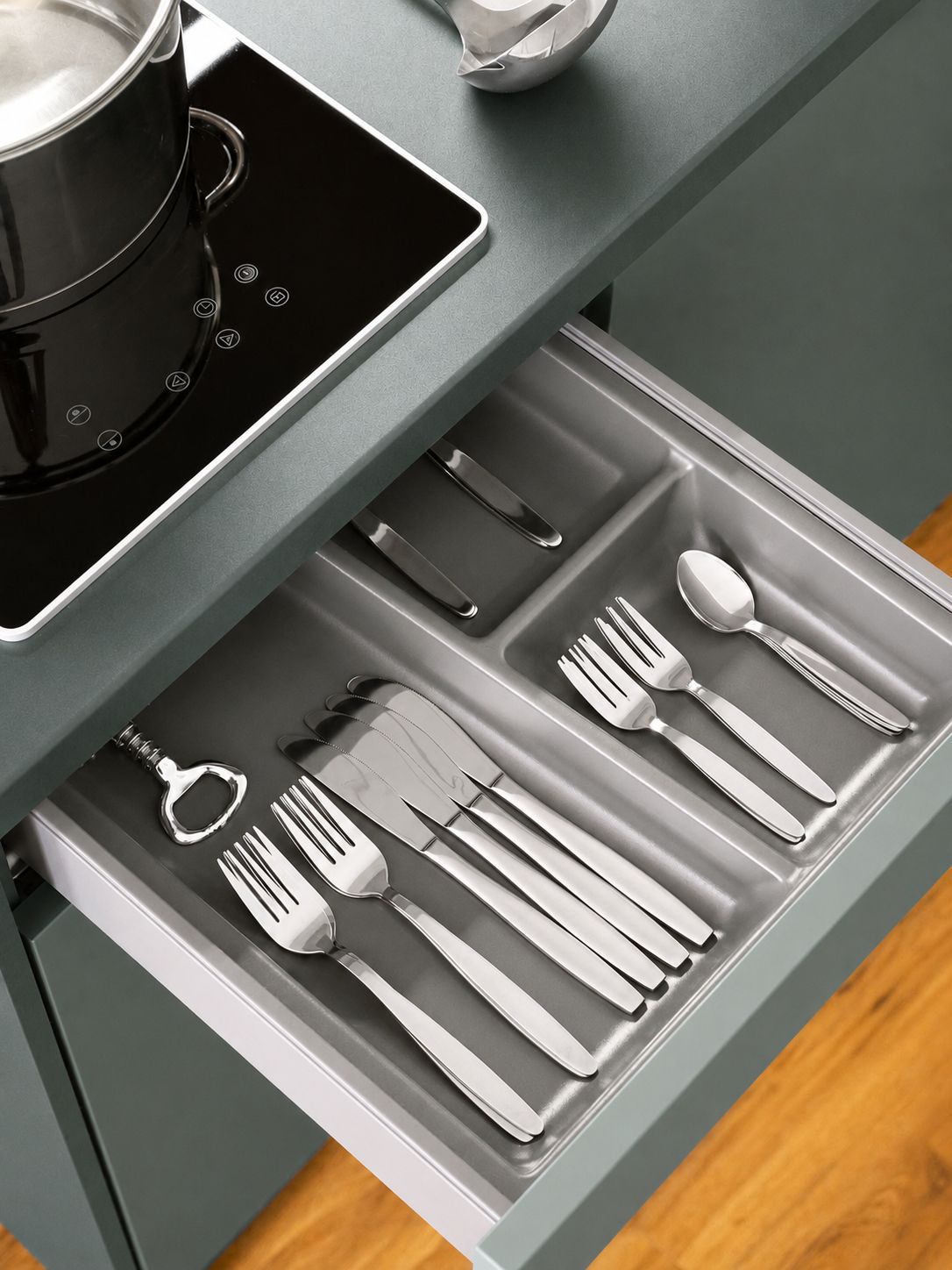 A drawer with kitchen utensils including forks, knives, and a spoon.