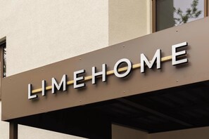 A sign with the word 'LIMEHOME' on a building facade.