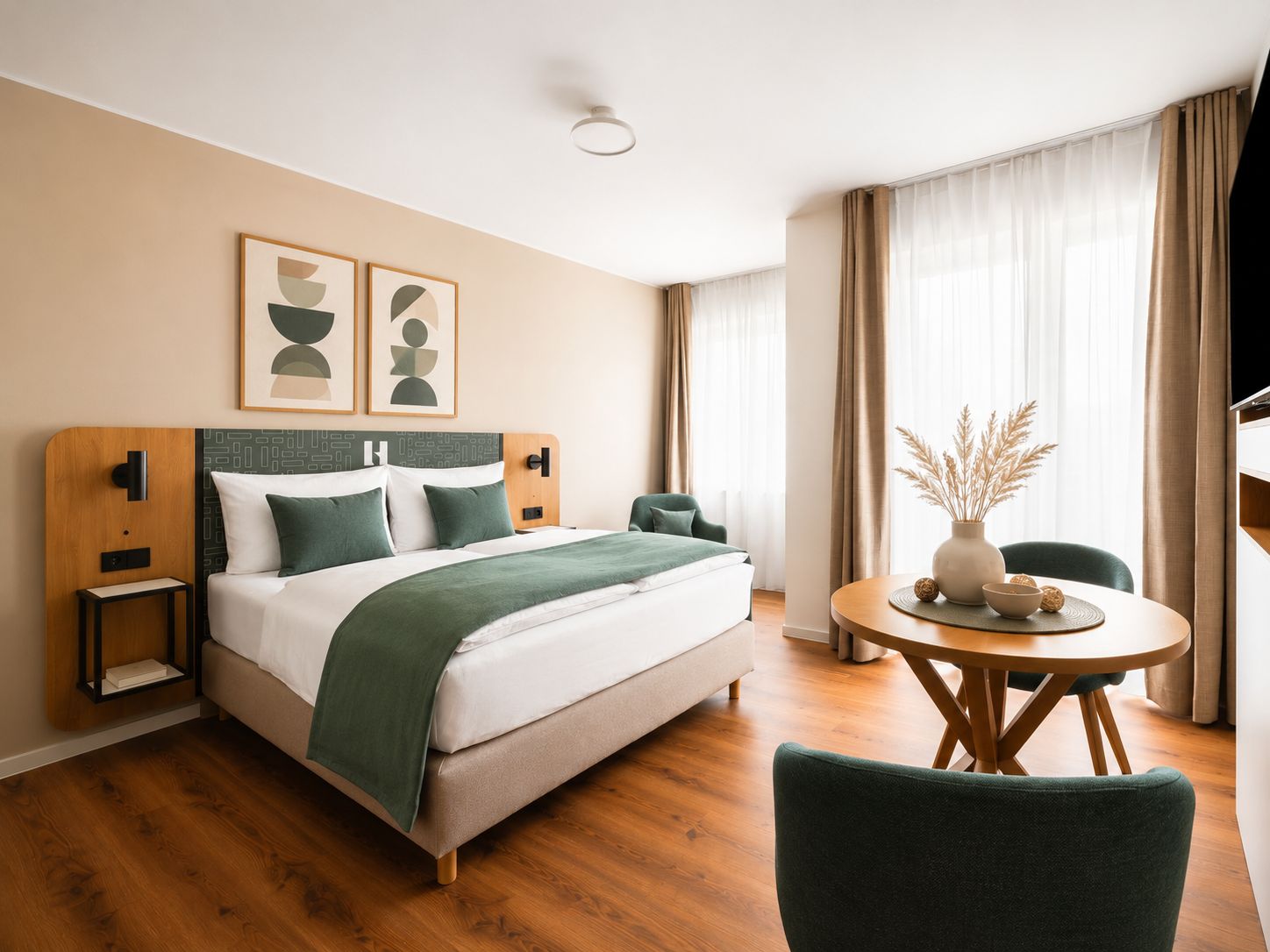 Une chambre d’hôtel comprenant un lit, des tables de chevet, une table à manger ronde avec des chaises et un téléviseur.