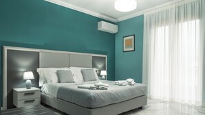 Un dormitorio moderno con una cama grande, mesitas de noche y un aire acondicionado instalado en el techo.