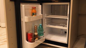 Ein offener Kühlschrank mit Orangensaft, einer Cola und einer Wasserflasche.