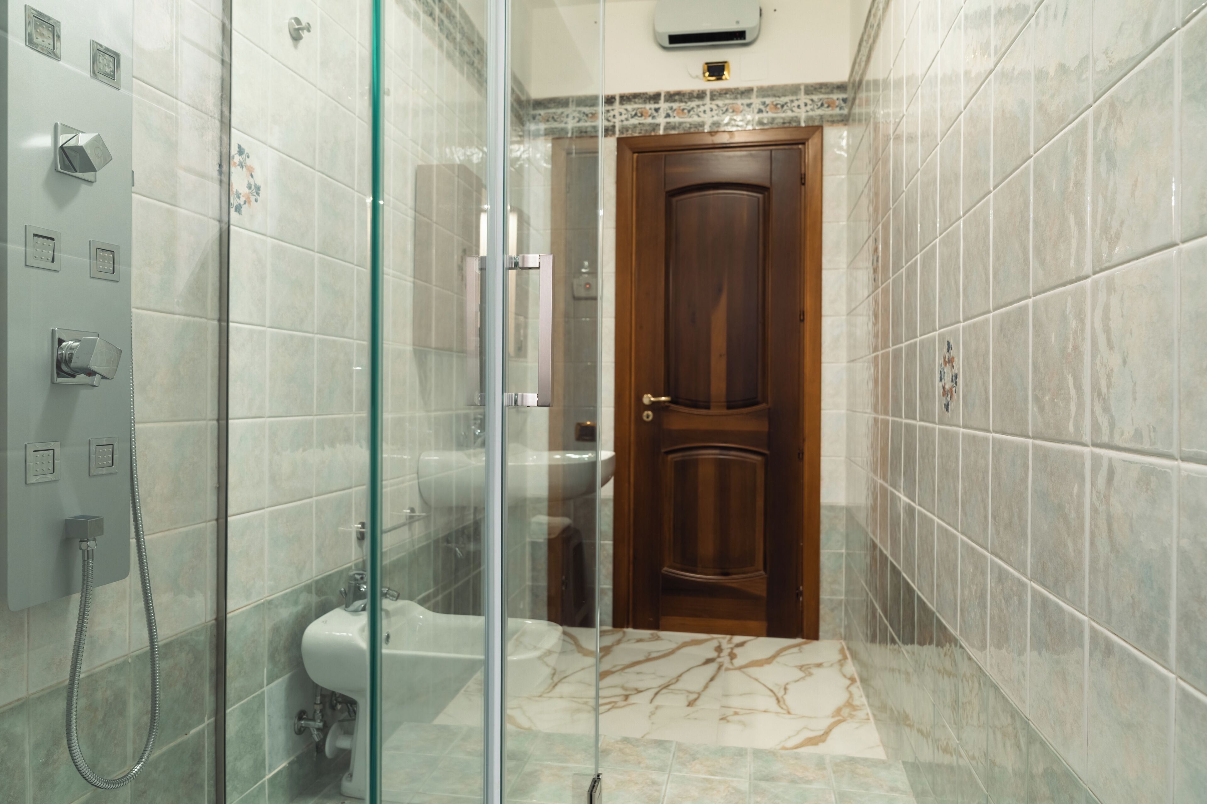 Une salle de bain avec une douche à parois en verre, des toilettes et un lavabo.