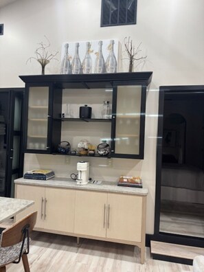 Una cucina con un mobile integrato, una macchina da caffè e oggetti decorativi sul piano di lavoro.