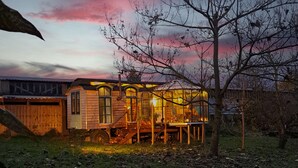 A wooden cabin with a glass extension, surrounded by trees and a wooden fence. - Tiny house # starry view # sauna # wild hot (Carinerland)