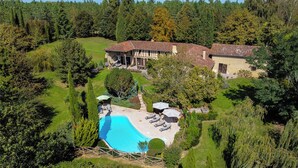 A large house with a swimming pool, surrounded by lush greenery and trees. - Tarrit de Bas with gated pool and total privacy (Castelnau d’Auzan Labarrère)