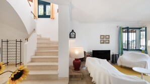 A staircase leading to a bedroom with a bed, a TV, and a lamp. - Villa with Pool 700 Meters from the Beach (Begur)