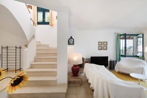A staircase leading to a bedroom with a bed, a TV, and a lamp. - Villa with Pool 700 Meters from the Beach (Begur)