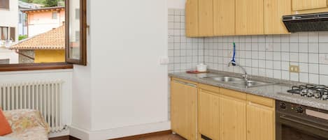 Een koelkast, een oven, kookgerei, borden en bestek