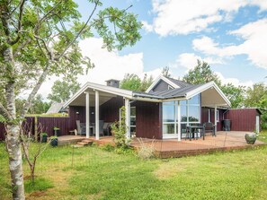 A modern house with a covered patio, a deck, and a large glass window. - 5 Star Holiday Home in Hadsund (Hadsund)