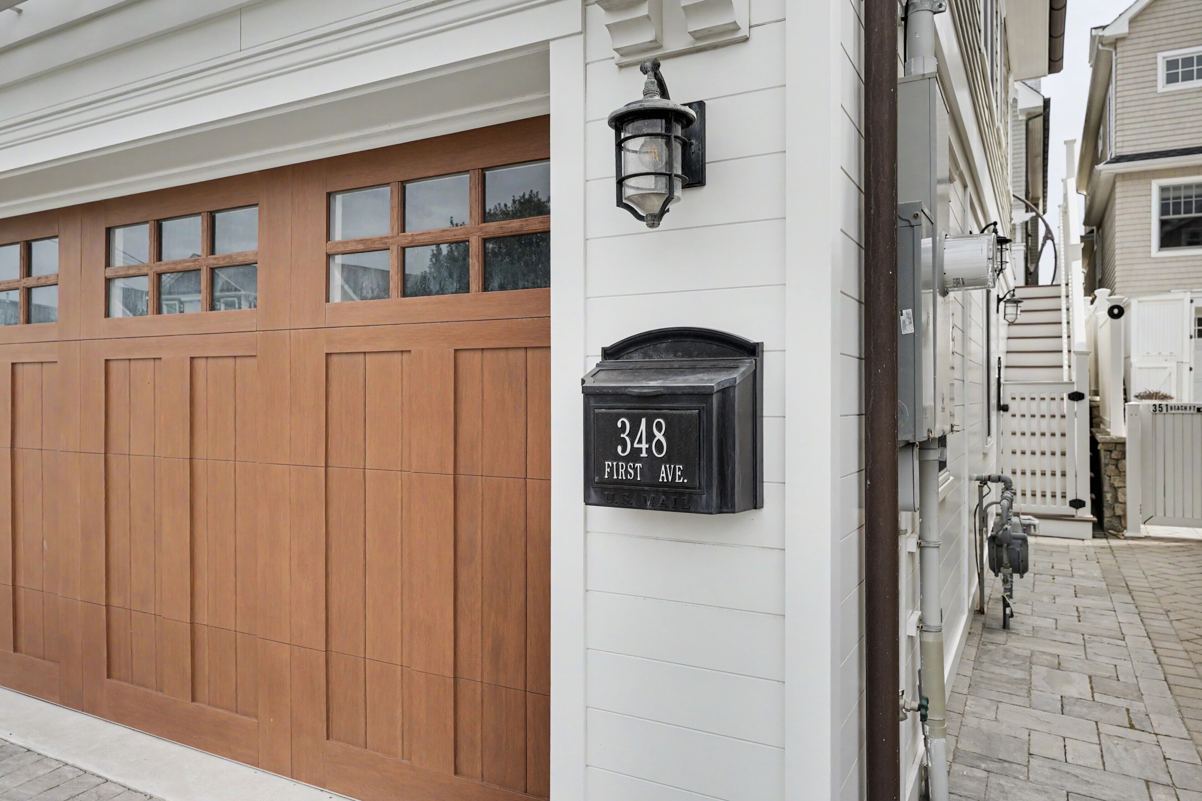 A garage door with a mailbox labeled '348 First Ave.'