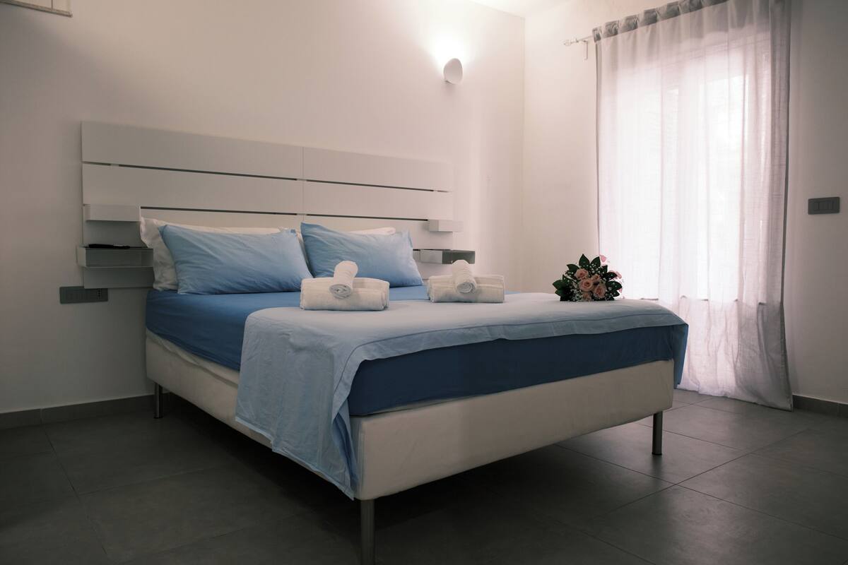 Ein modernes Schlafzimmer mit einem Bett, Kissen und einem Nachttisch.