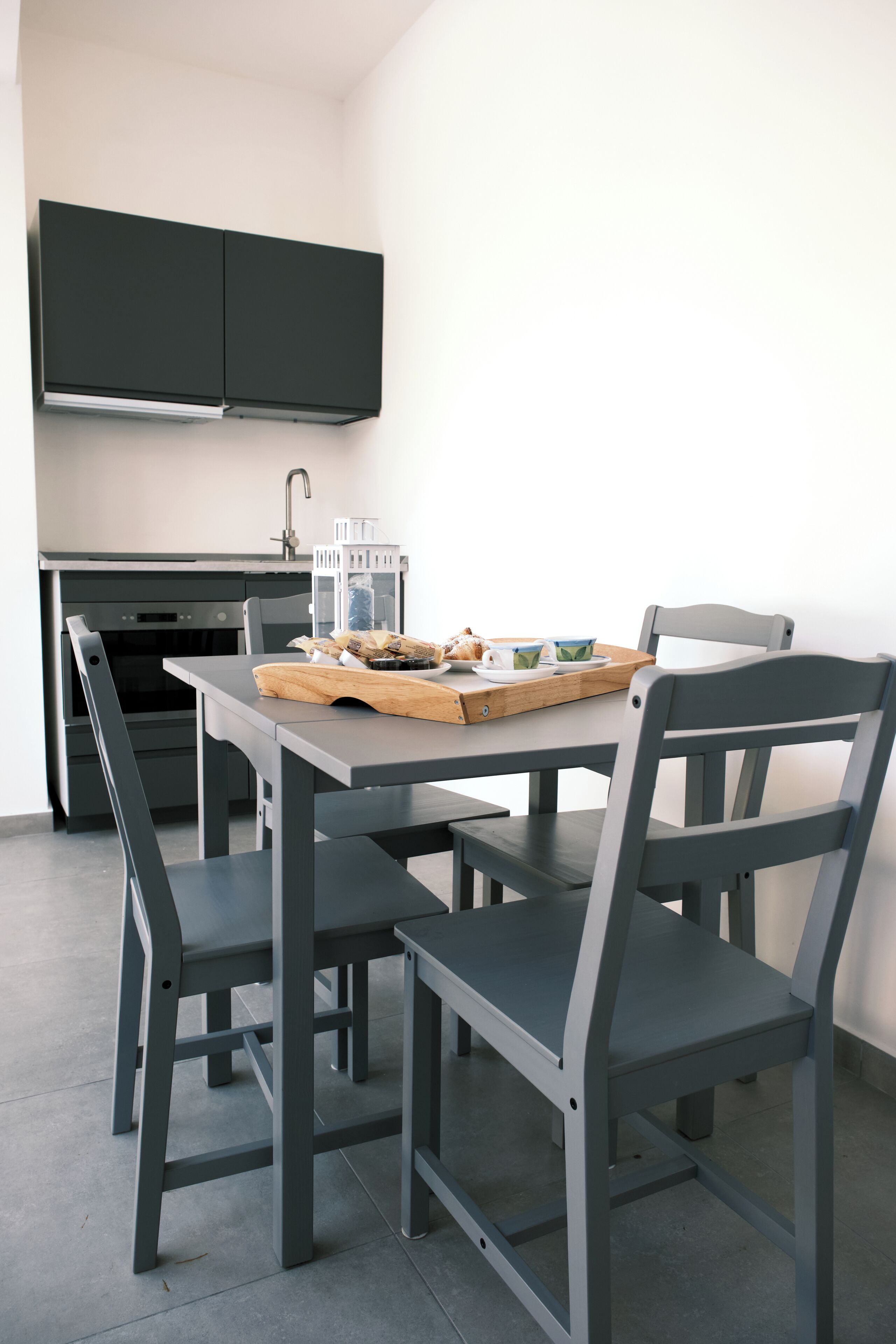 A modern kitchen with a dining table, chairs, and a breakfast tray.