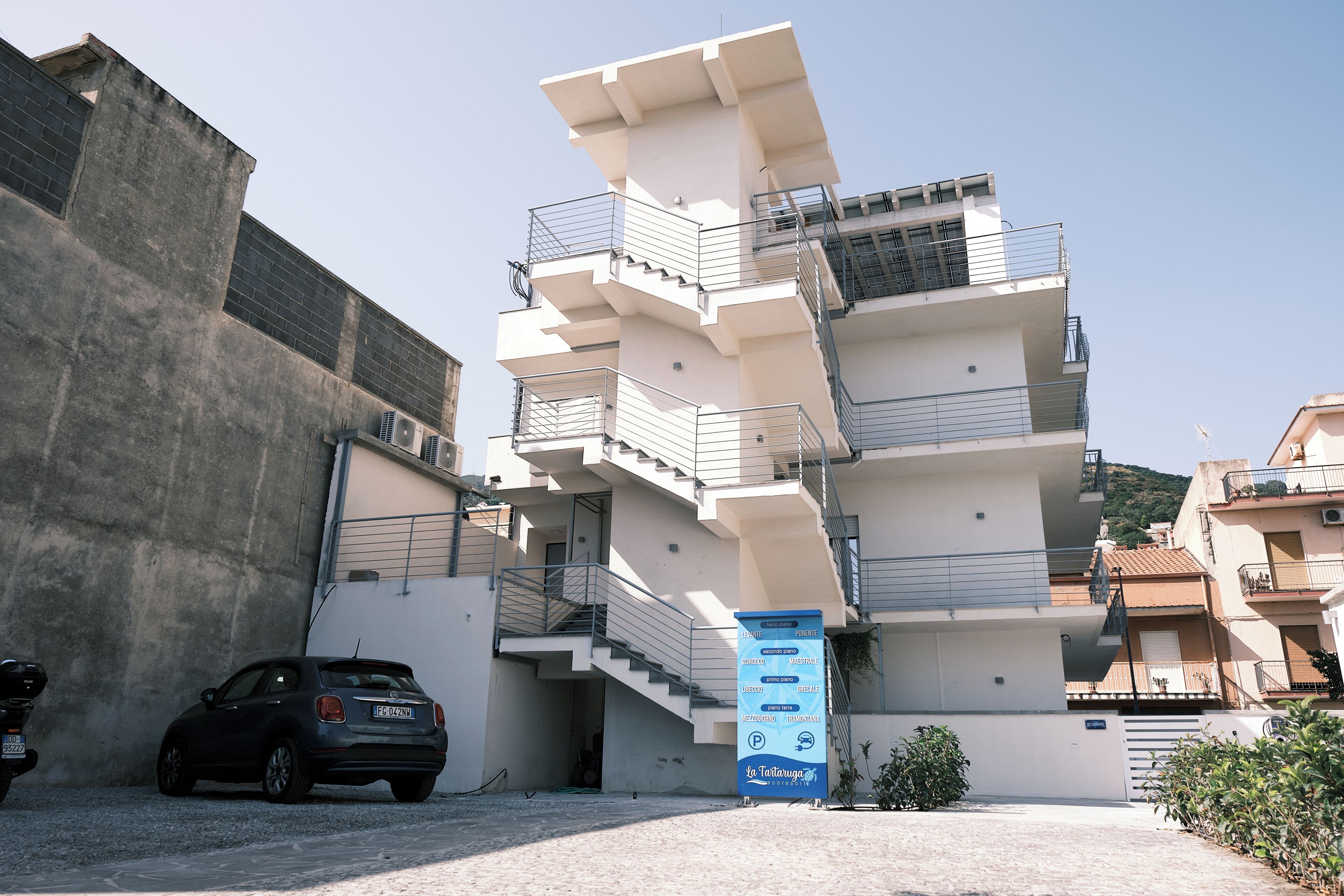 A multi-story building with a unique architectural design, featuring a central staircase and balconies.