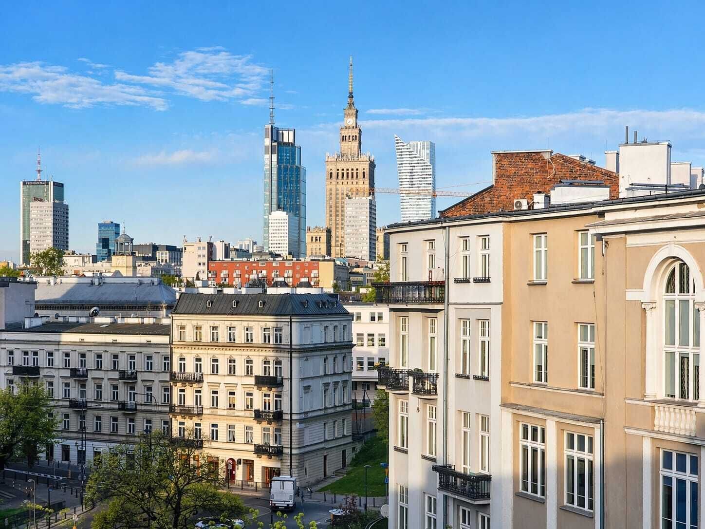 A cityscape with historic and modern buildings, including a prominent clock tower and a modern skyscraper.