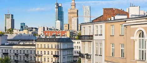 A cityscape with historic and modern buildings, including a prominent clock tower and a modern skyscraper.