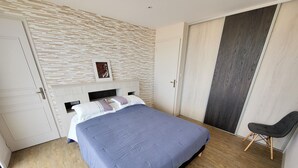 Un dormitorio con una cama, una silla, un armario y una pared con textura.