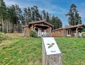 A wooden cabin with a porch, a sign reading 'Houx,' and a grassy area in front. - Natural chalet, pets allowed - 6 guests (Usson-en-Forez)