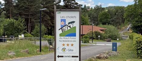 Señal para 'Les chalets du Haut-Forez' con una flecha indicando la entrada a la izquierda.