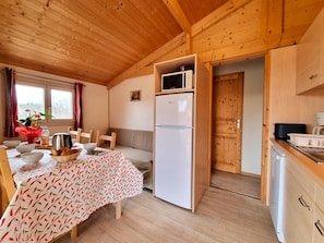 A compact kitchen with a microwave, refrigerator, and wooden cabinets. - Nature chalet, pets welcome - 6 guests (Usson-en-Forez)