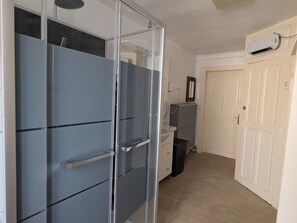 Une pièce dotée d’un placard avec porte coulissante, d’un radiateur, d’un lavabo et d’un miroir fixé au mur.