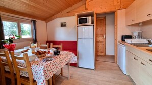 A compact kitchen with a microwave, refrigerator, and wooden cabinets. - Nature chalet, pets welcome - 6 guests (Usson-en-Forez)