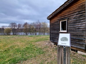 A wooden cabin with a sign labeled 'Laurier' in front of a lake. - Chalet, pets welcome, preserved nature - 4 guests (Usson-en-Forez)
