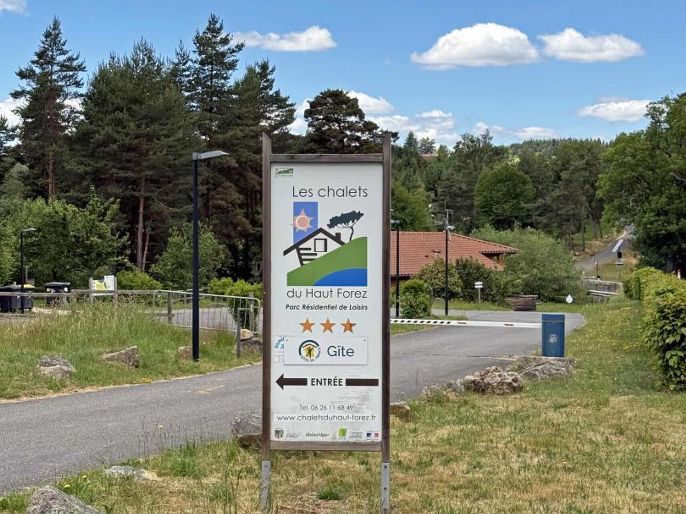 Señal para 'Les chalets du Haut-Forez' con una flecha indicando la entrada a la izquierda.