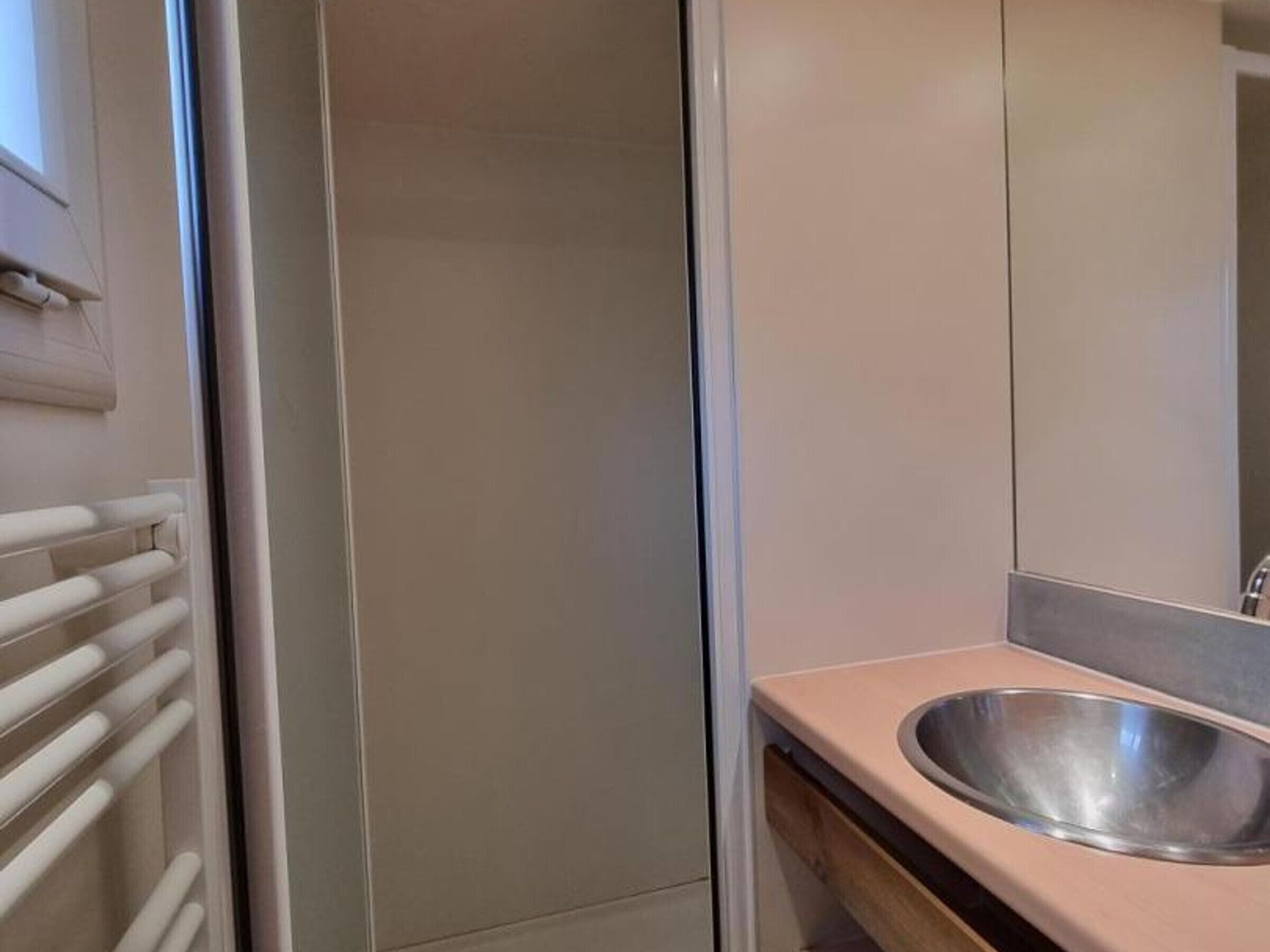 A bathroom with a white towel rack, a mirror, and a sink.