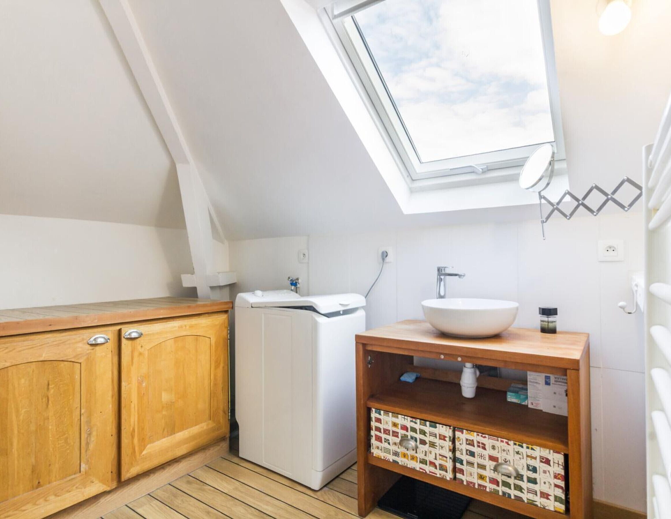 A small, modern kitchen with a skylight, wooden cabinets, a white refrigerator, and a wooden countertop.