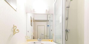 Ein Badezimmer mit Waschbecken, Spiegel und Dusche.