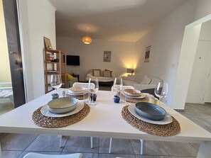 A dining table set with plates, glasses, and a woven placemat. - Bright apartment near town center - 5 guests (Calvi)