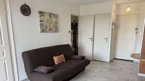Ein Wohnzimmer mit einer braunen Couch, einem Couchtisch und einem Gemälde an der Wand.