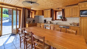 A spacious kitchen with wooden cabinets, a large island, and a ceiling fan.