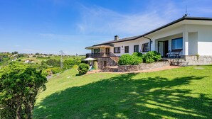 A modern house with a balcony, a stone pathway, and a grassy lawn. - Holiday Home 'Finca Tolombreo Casa Gabriel' in Cudillero (Cudillero)